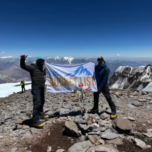 Bucket List Company flag displayed on the summit of Mount Aconcagua in Argentina