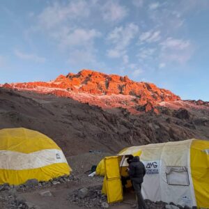 High-altitude base camp tents on Aconcagua with dramatic mountain scenery at sunset