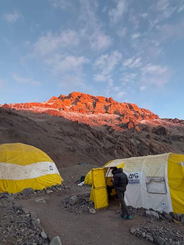 High-altitude base camp tents on Aconcagua with dramatic mountain scenery at sunset
