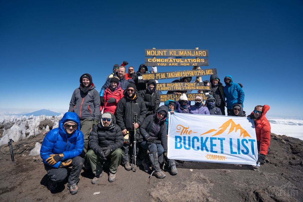 Group of climbers celebrating at Uhuru Peak on Mount Kilimanjaro via the Marangu Route