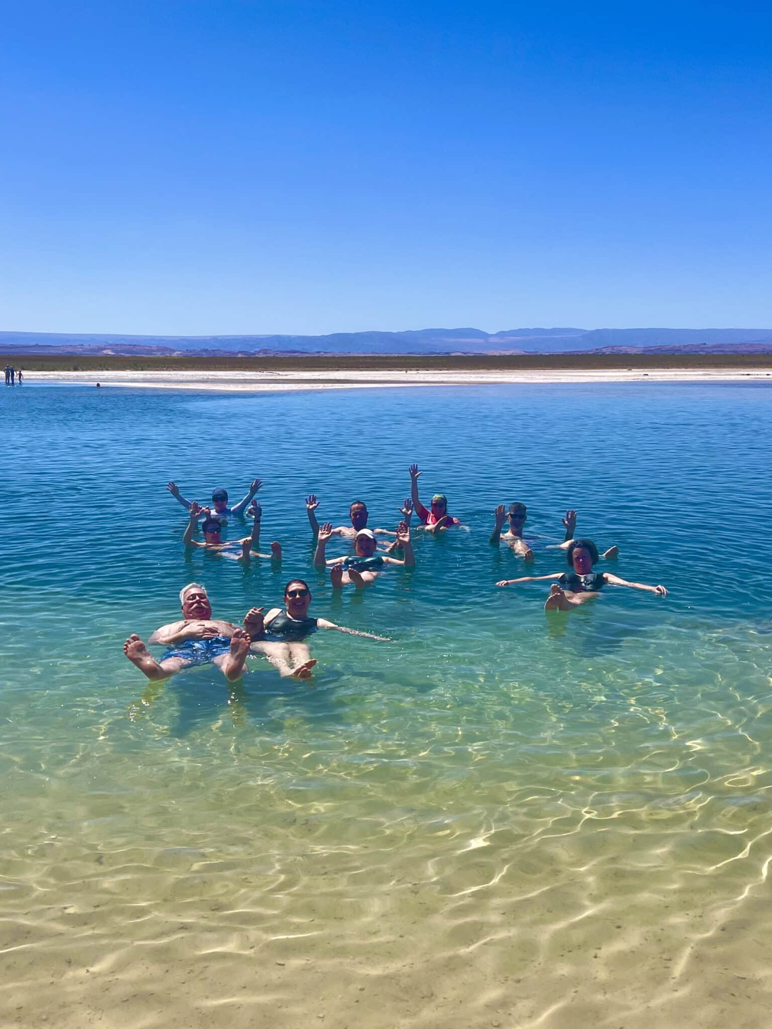 Group floating in a turquoise lagoon in the Atacama Desert