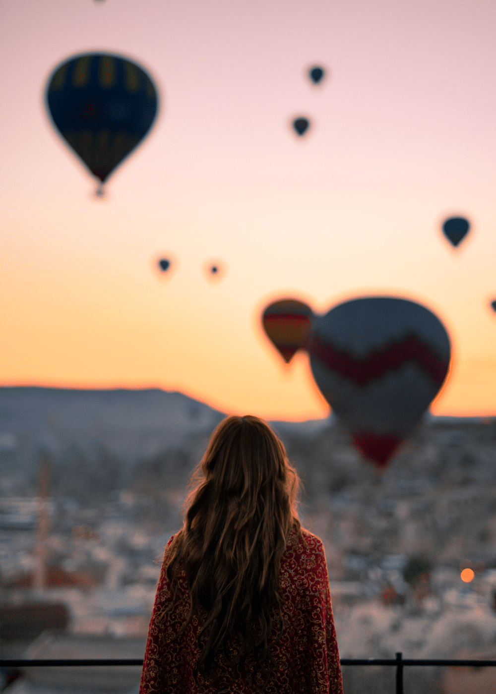 Unveiling the Mysteries of Cappadocia: A Traveller's Guide - lady standing in front of hot air balloons