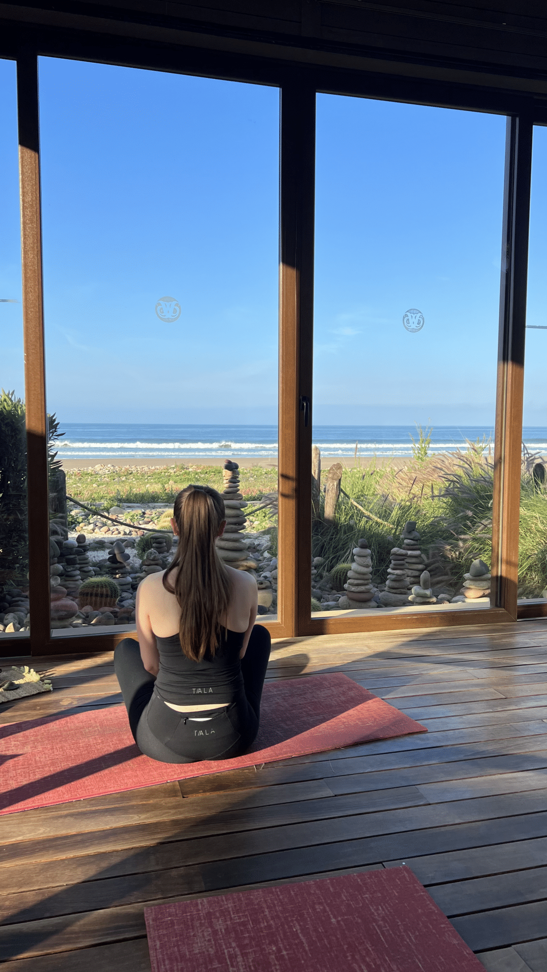 Experience the Ultimate Surf and Yoga Retreat in Morocco - girl sitting at yoga area looking at beach