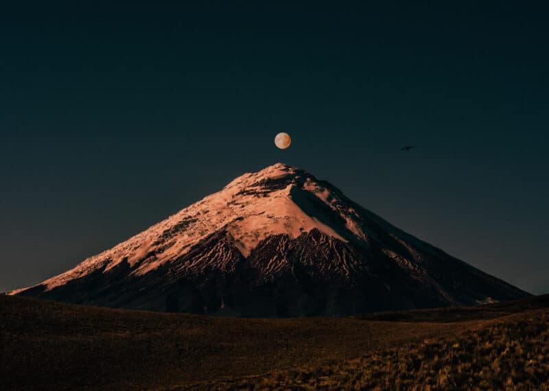 Snow-capped Cotopaxi volcano under a dramatic night sky in Ecuador
