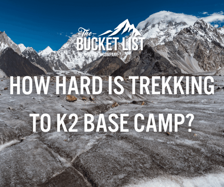 A rugged mountain landscape with snow capped peaks and rocky ground overlaid with the question: "How Hard Is Trekking To K Base Camp?" and "The Bucket List Company" at the top alongside a mountain logo