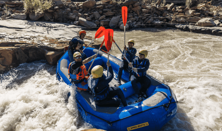 Group celebrating while white water rafting on the Ahansal River in Morocco
