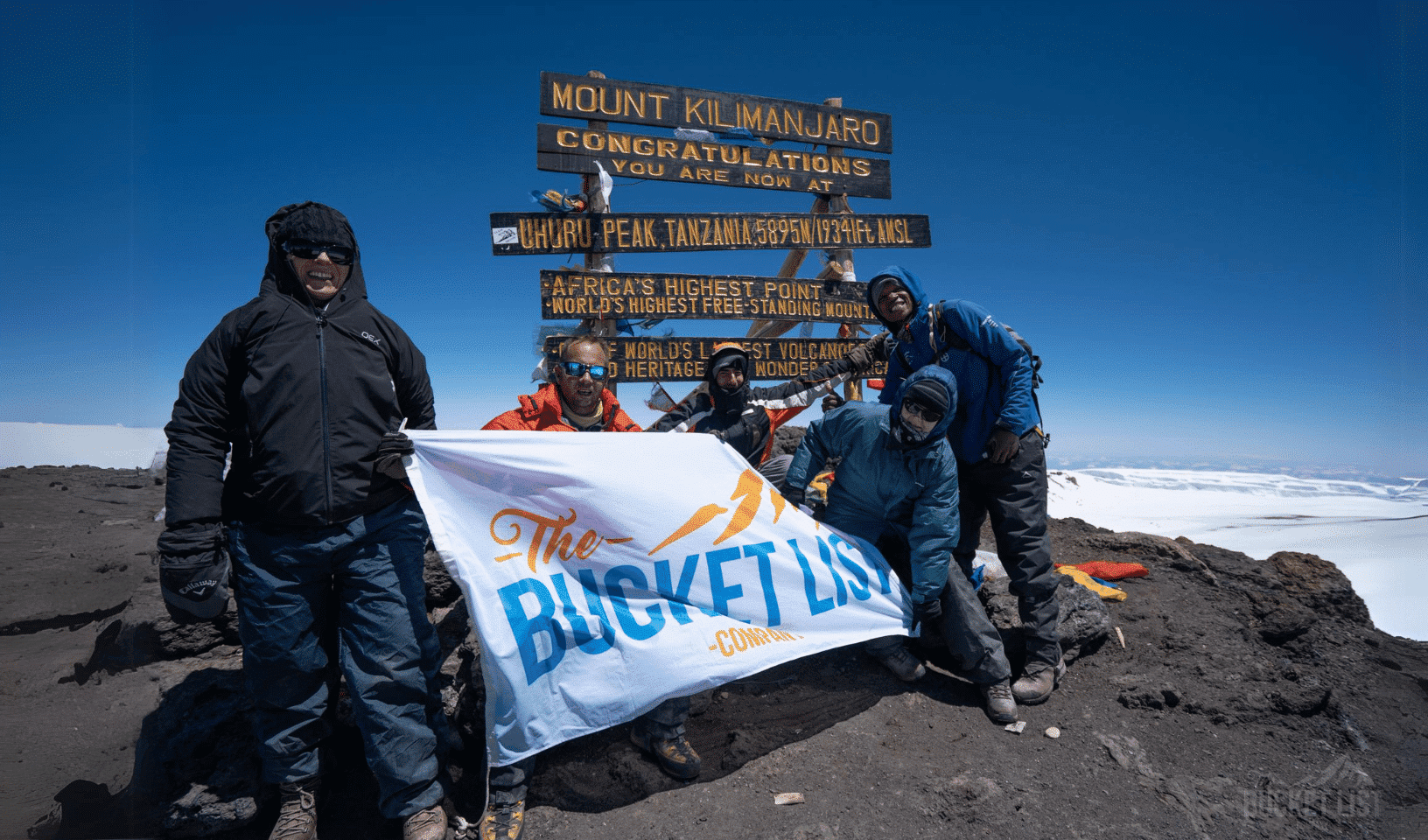 Climbers celebrating at Uhuru Peak on Mount Kilimanjaro